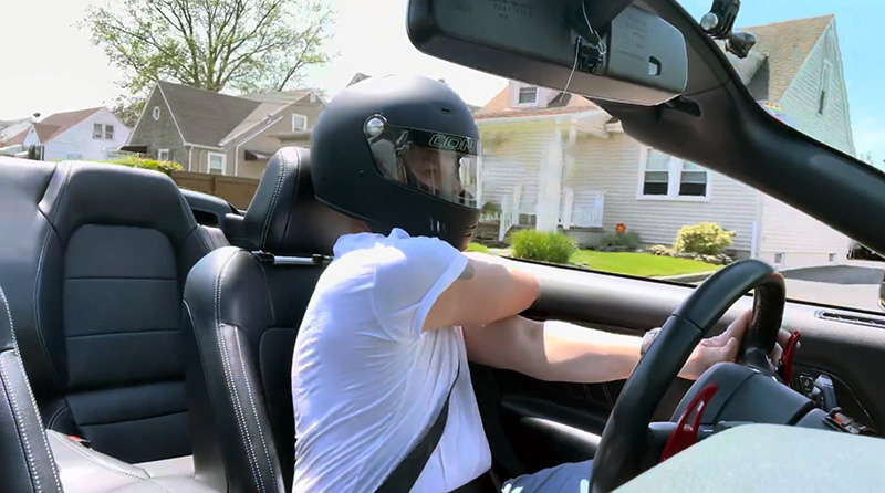 Guy driving open top car wearing helmet